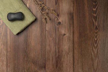 Charcoal black soap on a towel on a wooden background. Spa concept