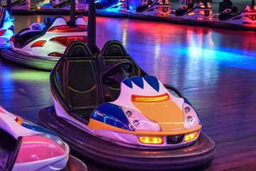 Coche de choque por delante con luces encendidas, en el parque de atracciones por la noche