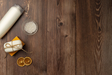 Bathing cosmetics and accessories on wooden background.