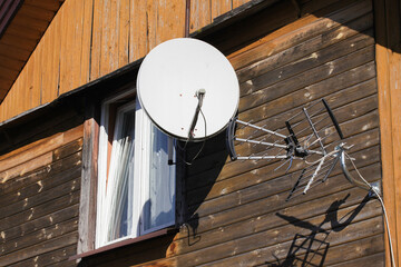 Tile roof antenna background. TV satelite dish old house roof. Countryside village architecture...
