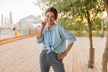 Fototapeta premium young pretty woman in casual summer style in modern park street