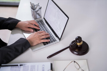 Male lawyer typing data and reading financial document of business on laptop to analysis about...
