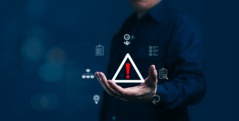 Businessman is holding caution symbol that is risk management