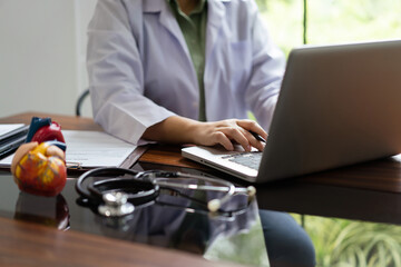Female cardiologist doctor researching medical data on laptop to analysis cardiology treatment