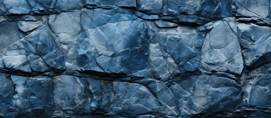 A detailed close-up of a rock wall covered in blue paint, showcasing the textures and patterns of the surface.
