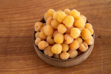 Yellow raspberries in a wooden bowl on the table. Summer berries background. Vitamin food, berry harvest. Healthy nutrition.