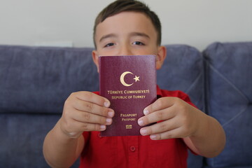 Little boy holding Turkish passport
