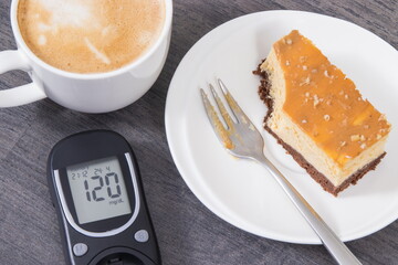 Glucose meter with high result sugar level, portion of sweet cheesecake and cup of coffee with...