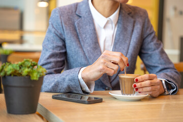  Business woman in a trendy cafe drinking coffee. with mobile on the table,beautiful caucasian.