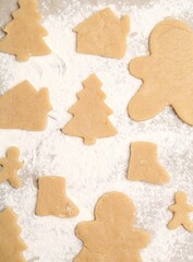 Raw Christmas cookies in different shapes on parchment paper, flat lay