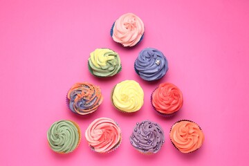 Delicious cupcake with bright cream on pink background, flat lay