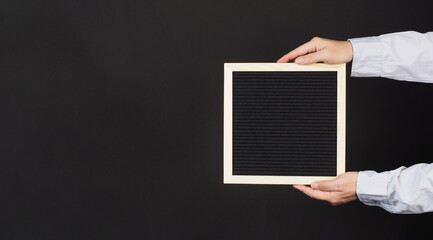 Black Changeable letter board. In hands with horizontal frame.
