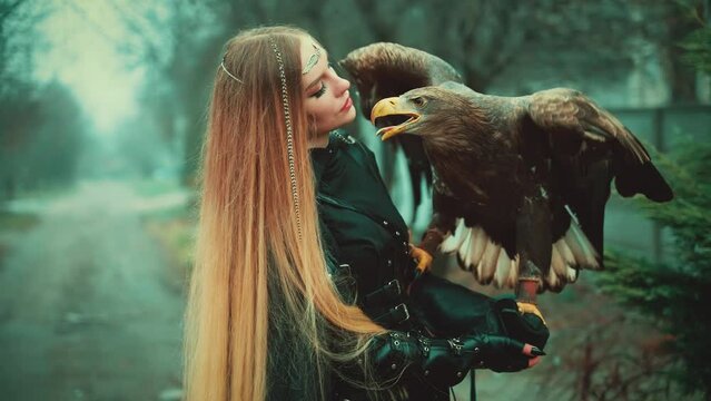 art fantasy woman warrior holding white-tailed eagle wild bird on hand animal pet flaps brown big wings, girl blond hair Sexy face fashion model. Lady queen hunter black dress armor. dark trees fog 4k