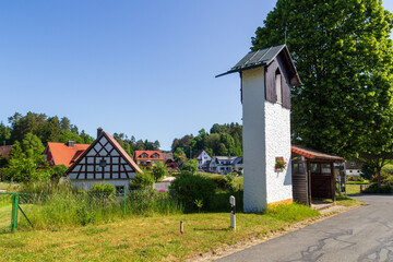 Bell tower and houses in village Herzogwind, district of Obertrubach (Franconian Switzerland), Bavaria, Germany - obrazy, fototapety, plakaty