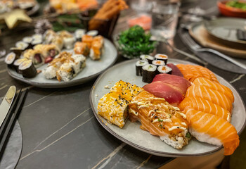 den haag, netherlands - 20 december 2021: a dish on a festivily decorated table with japanese sushi rolls with raw fish
