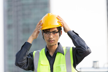 Asian male engineer wearing safety helmet during preparing working at construction site area