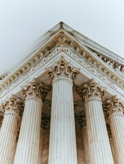 Naklejka premium Low Angle View of US Supreme Court Justice Building Exterior Marble Columns, White Sky Background
