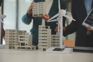 Close-up at tablet, Engineers pointing at tablet with their hands. To jointly design the use of renewable energy with wind and solar energy. Concept of using renewable energy.