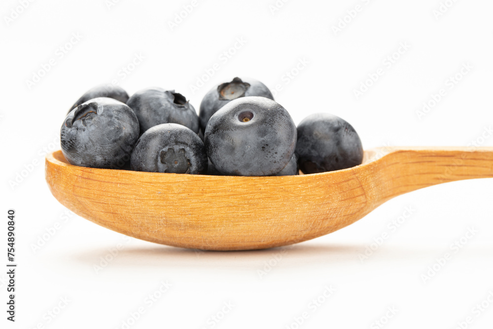 Wall mural Wild blueberry in a wooden spoon isolated on a white background.