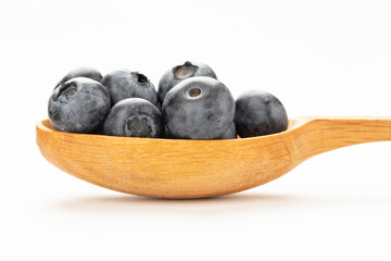 Wild blueberry in a wooden spoon isolated on a white background.