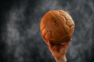 Hand mit einem alten Lederfussball