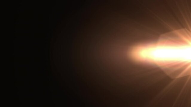 Abstract center glow gold optical lens flares light animation moving from left to right side on black background. 