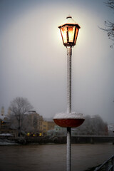 The street lamps are lit at night in winter.Lighting in the dark in a snowstorm.