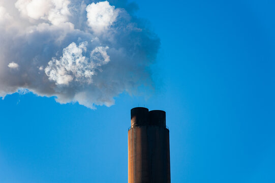 Closeup of the top of a smokestack releasing steam at a power plant in Rome, Georgia