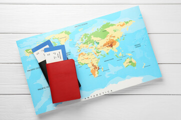 Honeymoon concept. Plane tickets, passports and world map on white wooden table, top view