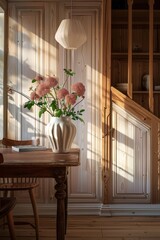 Cozy interior with afternoon light filtering through, highlighting a vase of flowers on a wooden table.