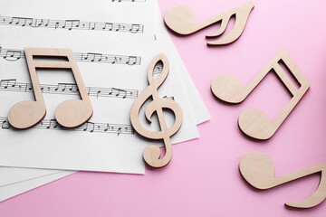 Baby songs. Music sheets and wooden notes on pink background, flat lay