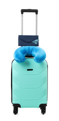 Soft travel pillow and purse on turquoise suitcase isolated on white