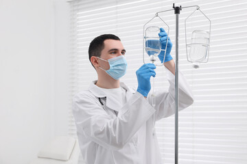 Doctor setting up IV drip in hospital