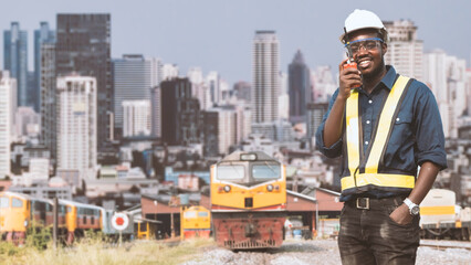 African mechanical engineer talking with radio communication or walkie talkie to maintain train in...