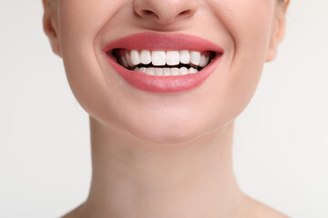 Young woman with beautiful smile on white background, closeup