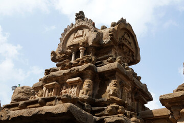 Kailasanathar Temple tower against blue sky background. Ancient Hindu temple gopuram with carved sandstone sculptures of God.