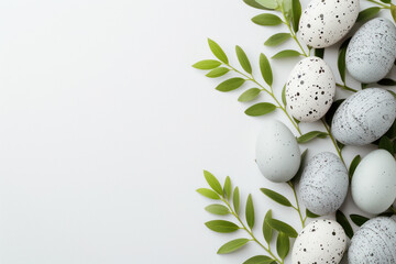 Obraz na płótnie Canvas Gray Easter eggs and branches of greenery on a white background with copy space.