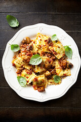 Ravioli with mushrooms and fresh basil. Dark wooden background. Close up	