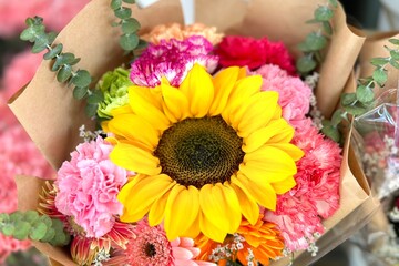 Stock Photo ID: 790091761
beautiful bouquet of mixed flowers in a vase on wooden table. the work of the florist at a flower shop. a bright mix of sunflowers, chrysanthemums and roses. background on fu
