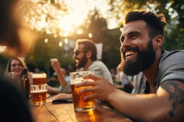 Foto op Canvas A man with a beard is holding a glass of beer and smiling © kiatipol