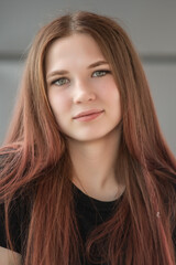 Fototapeta premium Portrait of a young beautiful red-haired girl in an urban environment.
