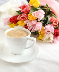 Bouquet of tulip flowers with cup of coffee 