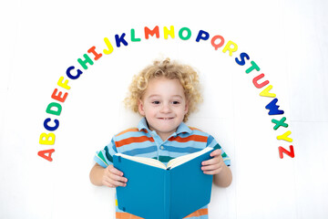 Child learning letters of alphabet and reading