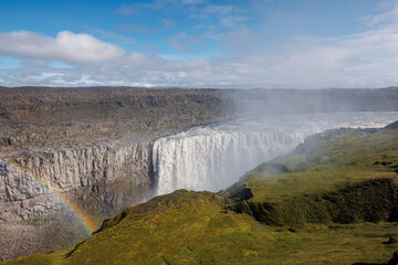 Majestic rainbow over Dettifoss waterfall in Iceland, the second most powerful waterfall in Europe, on a spring day