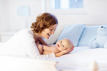 Mother and baby on a white bed