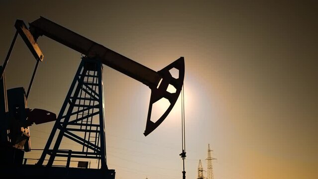 oil industry. silhouette of an oil pump extracts oil and gas lifestyle from ground of the field. business industry concept. pump pumps oil and gas at sunset. drill petroleum middle sunlight industry