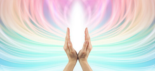 Colour energy healing background - hands making a v shape with white light between against a flowing ethereal multicoloured background with copy space all around
- 754962418