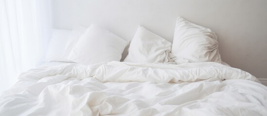 A messy bed with crumpled white sheets and pillows in a bedroom setting. The unmade bed suggests recent use and provides a sense of intimacy and comfort.