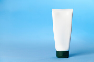 White sunscreen bottle on blue background. Sunscreen concept. Skin care concept. Copy space.