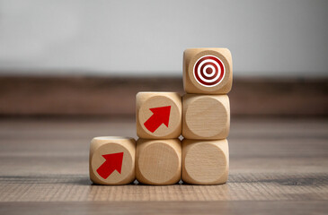 Cubes and dice with arrow and bow metaphor for goal or target on wooden background 